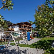 © Landhotel Tirolerhof/ Thomas Trinkl - Hotelansicht mit eigenem Kinderspielplatz 