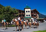 zusammenwarten-für-den-ausritt-im-hintergrund-das-landhotel-strasserwirt zusammenwarten-für-den-ausritt-im-hintergrund-das-landhotel-strasserwirt
